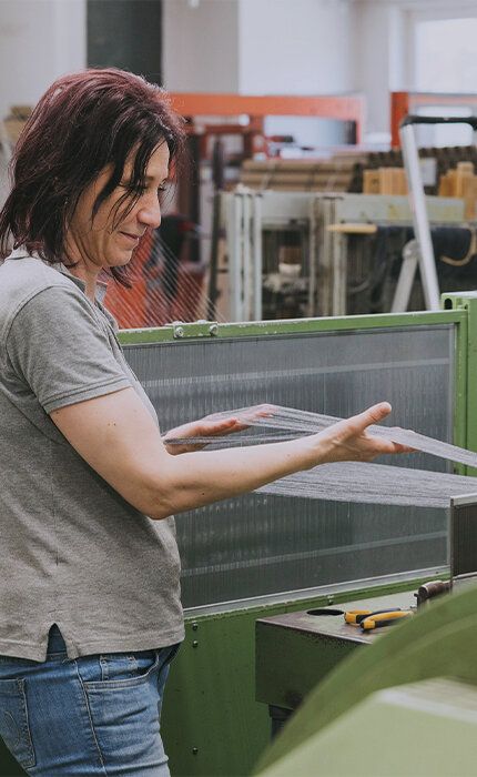 TTI Mitarbeiterin, die die Schärmaschine in Werk 2 kontrolliert